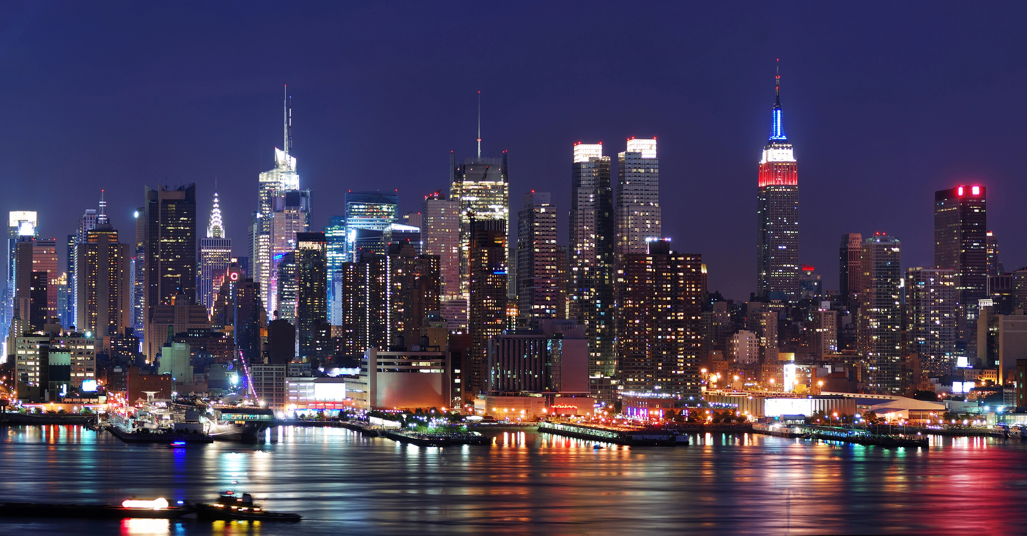 Aerial night view of Manhattan from over the Hudson River; NYC gun laws apply to visitors as well as residents of the city.